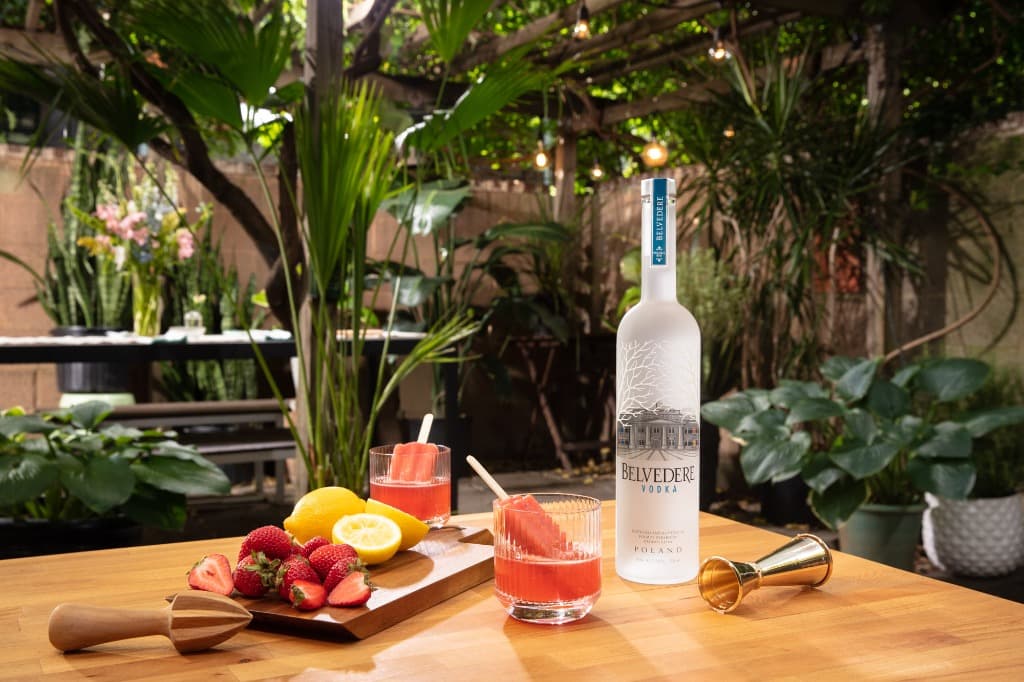 Lifestyle detail of Belvedere bottle with fresh strawberries and lemon