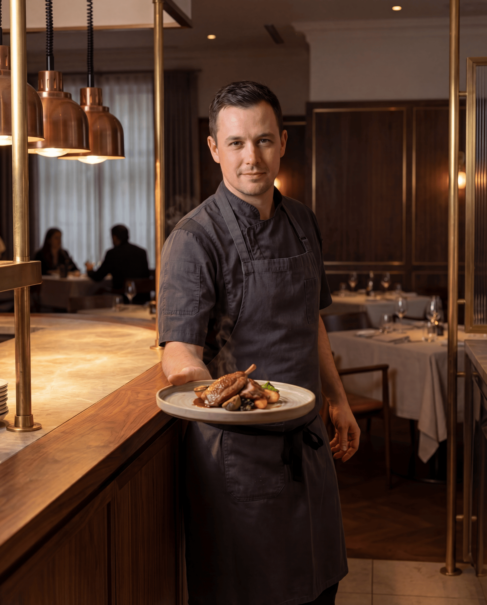 Executive chef presenting a signature culinary dish at an upscale restaurant