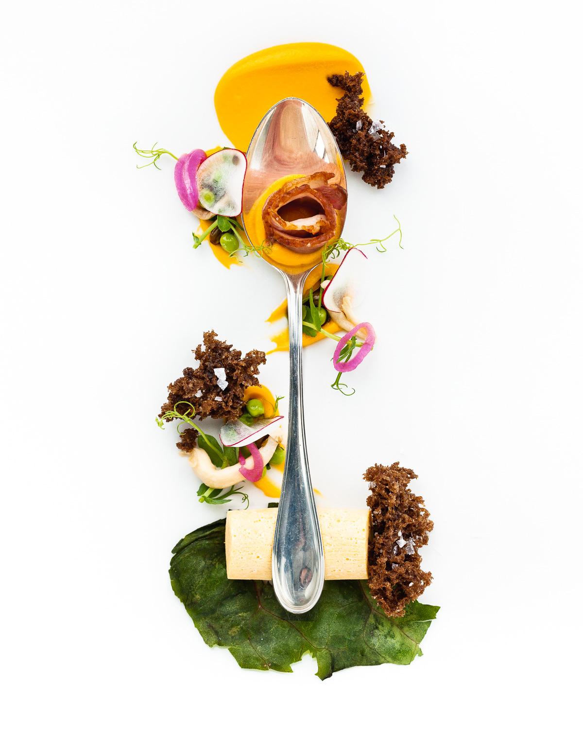 Spoonful portrait of Chef Edi Frauneder titled The Craft of Autumn, featuring smoked duck breast, squash puree, pumpernickel, dehydrated kale, pickled beech mushroom, and pea shoots in a silver spoon.