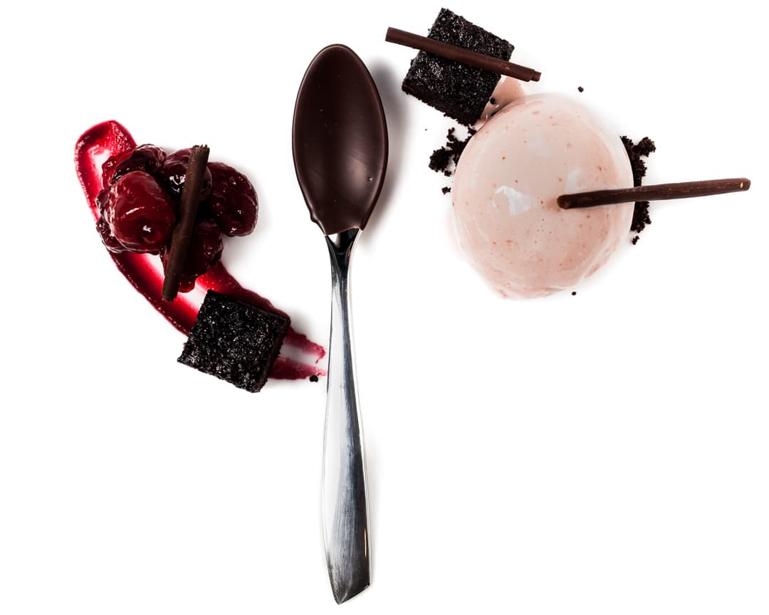 Spoonful portrait of Chef Joseph Murphy titled Black Forest, featuring chocolate-dipped cherries, krisch, and devil's food cake in a specialized ice cream quenelle spoon.