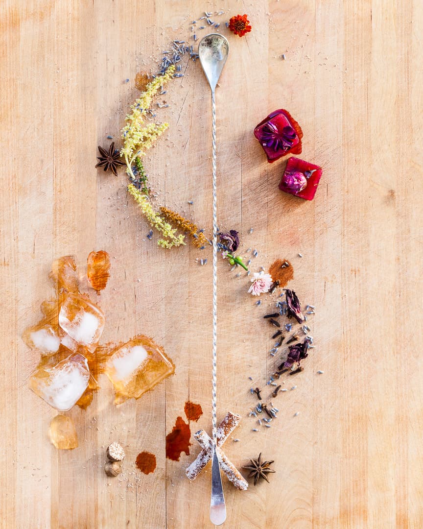 Spoonful portrait of Mercedes OBrien titled Endless Inspiration, featuring hibiscus and ginger ice cubes, local pollen, spices, and edible flowers alongside a bar spoon.