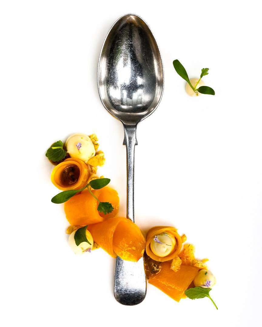 Spoonful portrait of Pastry Chef Ashley Brauze featuring champagne mangoes, ginger custard, and micro cilantro with a gifted Oneida print spoon.
