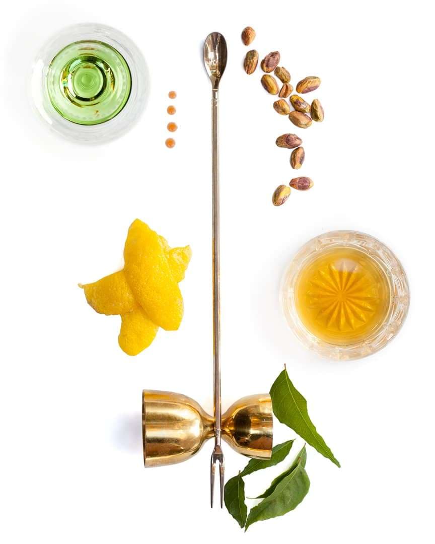 Spoonful portrait of Mixologist Jillian Vose featuring pistachio syrup, fresh curry leaves, and Irish whiskey with a trident bar spoon.